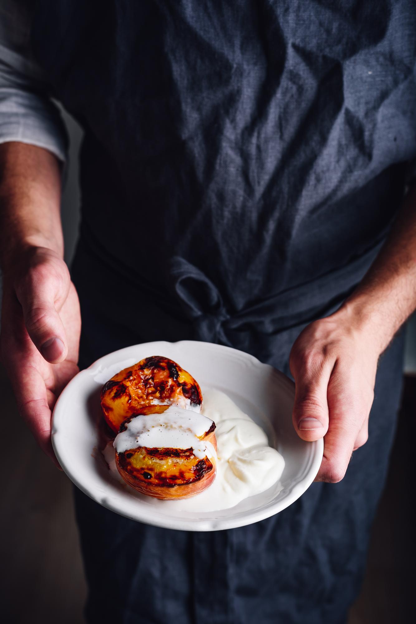 Instructor demonstrating plated dish in a warm studio